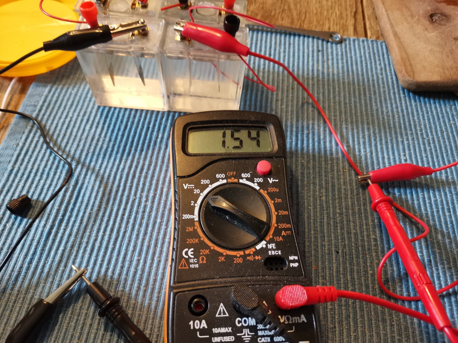 Digitalt multimeter der viser 1,54 volt, forbundet til cellerne